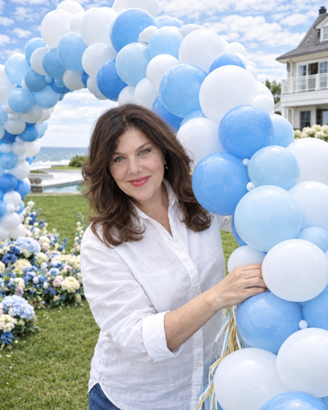 Hampton Party Shop stylist beside a powder-blue and white balloon arch in a Hamptons garden
